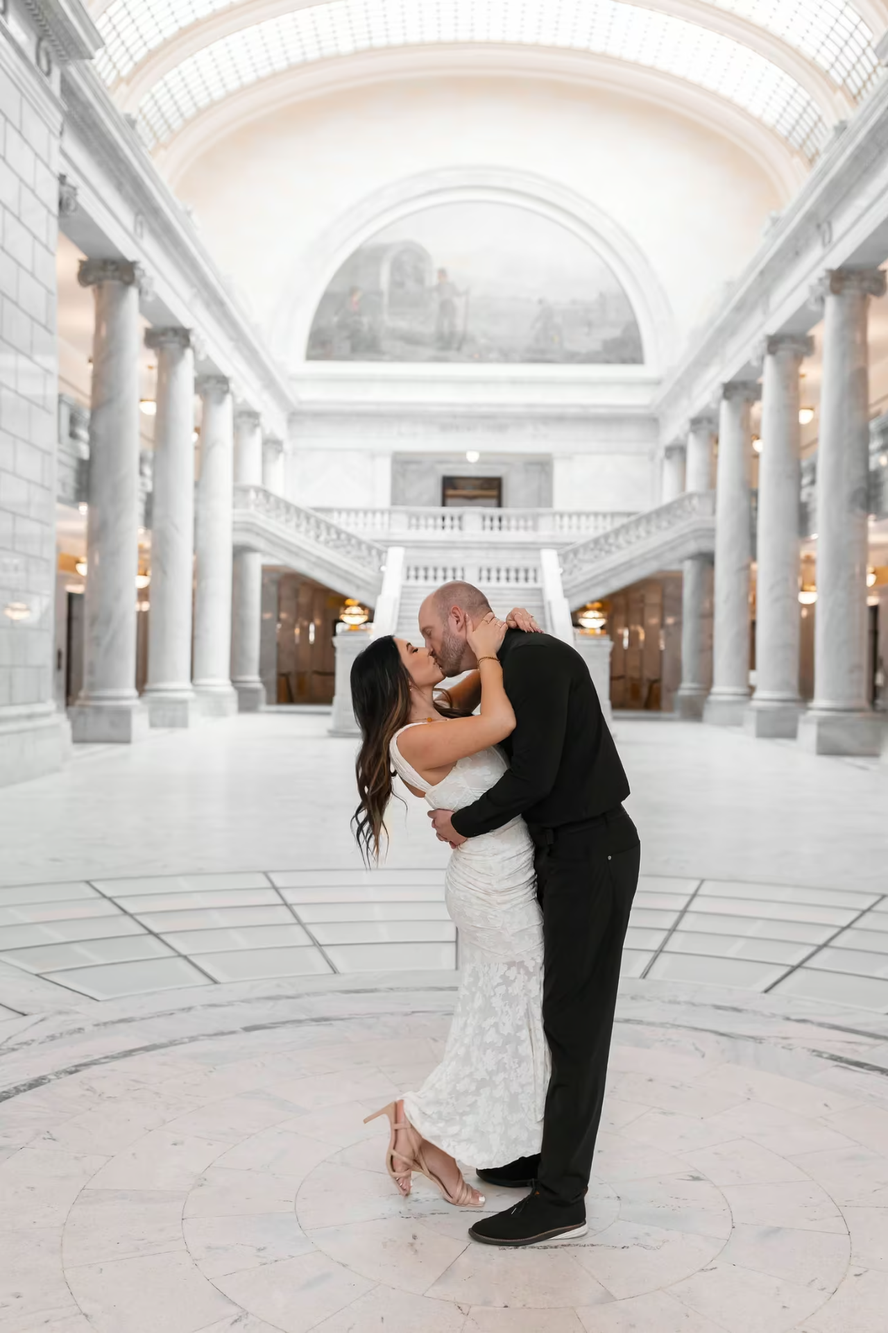 Travis and Chrissy kissing beneath the Utah State Capitol rotunda.