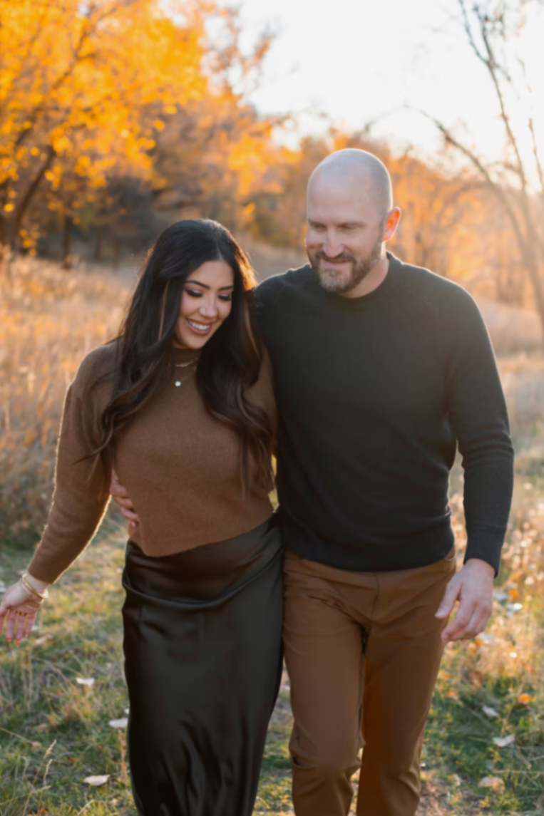 Travis and Chrissy walking together in autumn light.